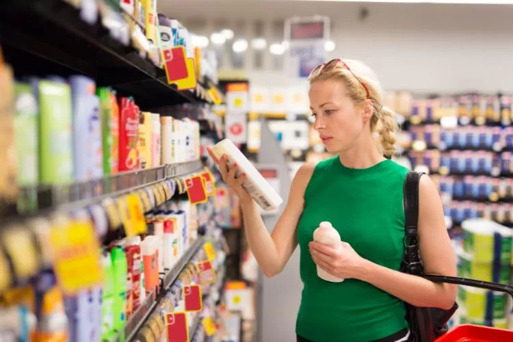Femme en train de faire ses achats dans les rayons d'un magasin bien achalandé
