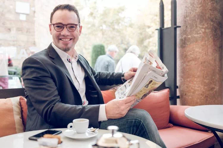 Homme dans un café en train de lire le journal