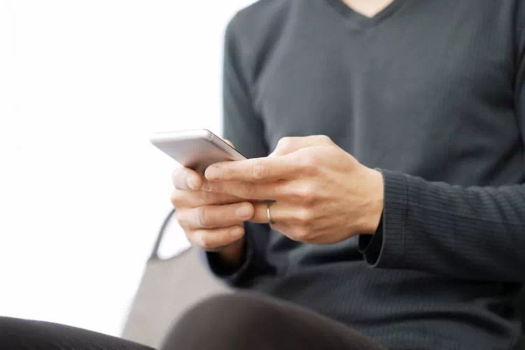 Homme regardant ses SMS sur son téléphone portable