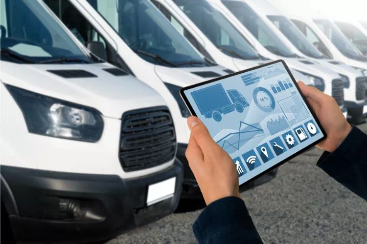 Homme dans un parking avec des utilitaires garés avec une tablette et un logiciel de gestion de flotte
