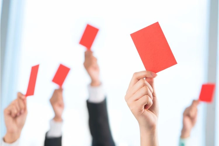 Cartons rouges levés pouvant représenter les objections possibles lors de la conclusion d'une affaire