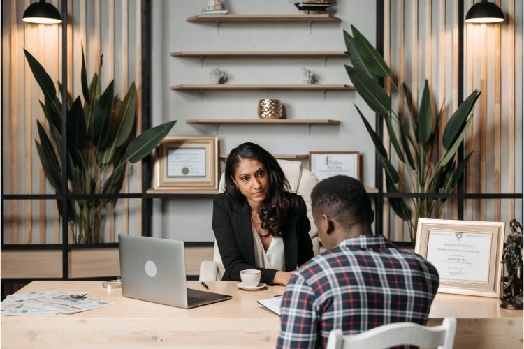 Femme recevant un client dans son bureau pour la conclusion d'une vente