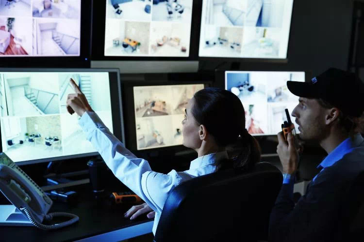 Deux agents de sécurité dans une salle de surveillance vidéo