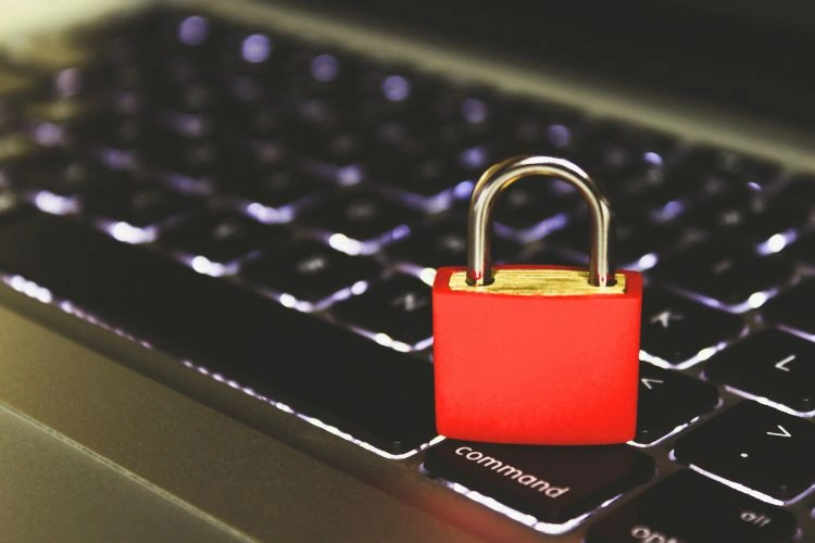 Clavier d'ordinateur avec un cadenas rouge posé dessus représentant les assurances cyber risques et cybercriminalité