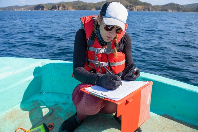 Femme biologiste marin en train de prendre des notes