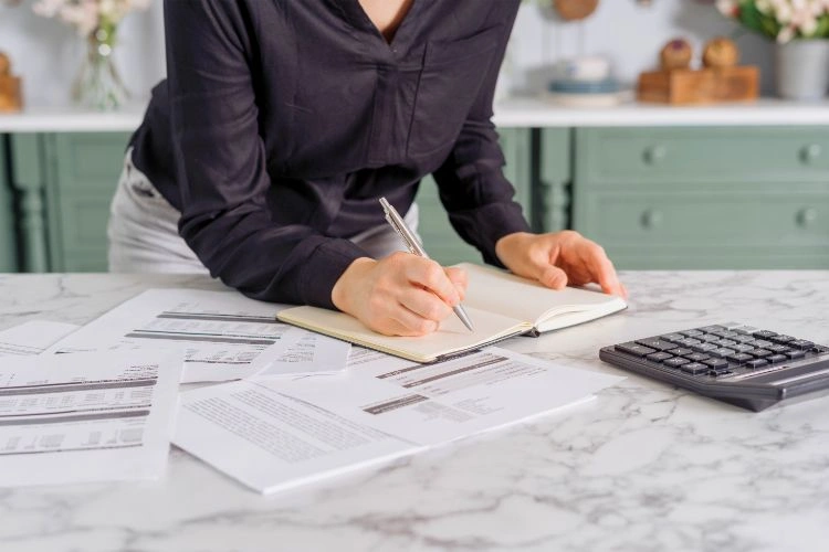 Femme en train de calculer le coût total d'un produit