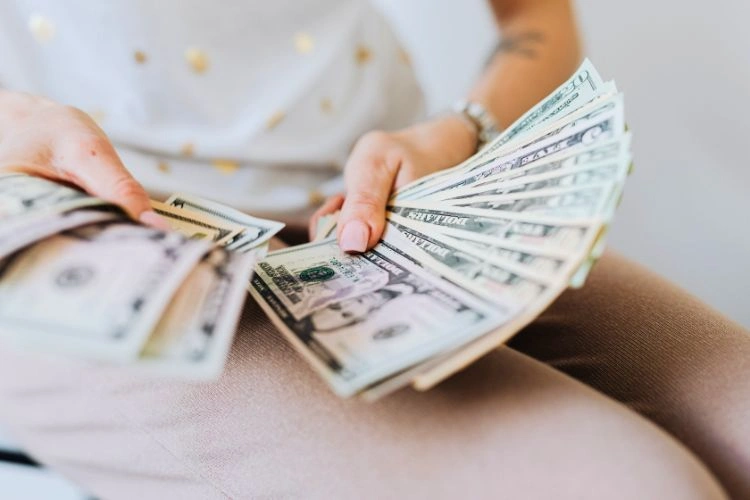 Personne avec des billets à la main représentant le salaire d'un biologiste marin