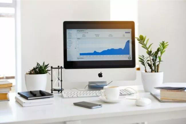 Bureau avec un Mac et du matériel pour travailler