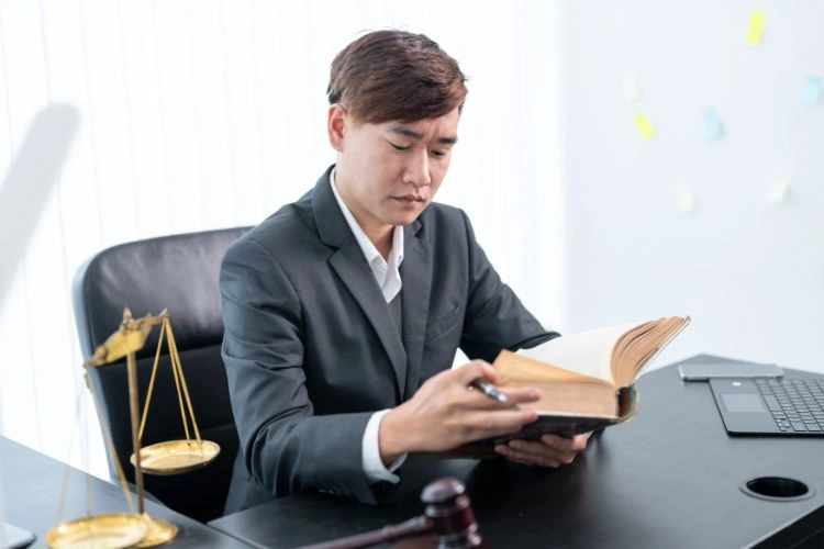 Homme dans son bureau avec une balance de justice pour représenter le métier de conseiller juridique