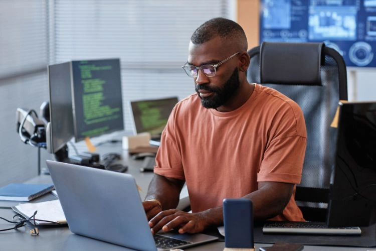Informaticien concentré devant ses écrans d'ordinateurs