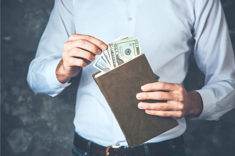 Homme tenant de l'argent représentant le salaire minimum d'un cadre