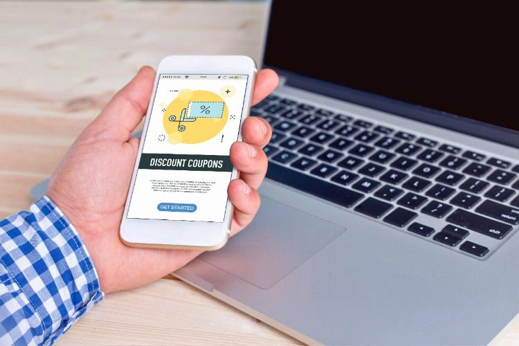 Homme utilisant un coupon de réduction en ligne