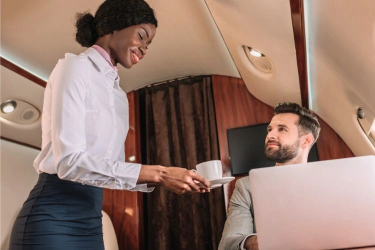 Femme hôtesse en train de servir un café dans l'avion