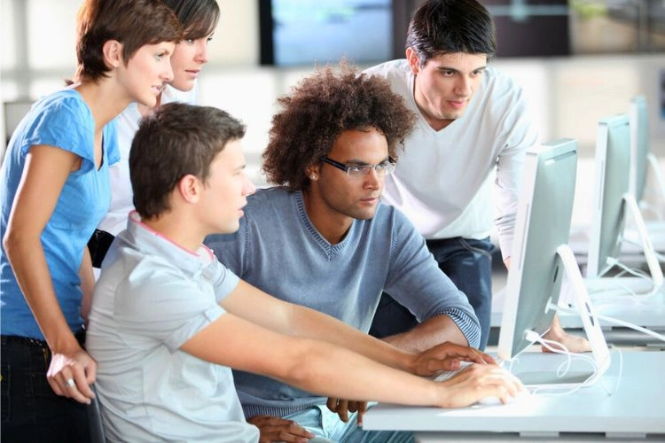 Groupe de jeunes devant un écran d'ordinateur pour représenter le salaire d'un jeune ingénieur informaticien