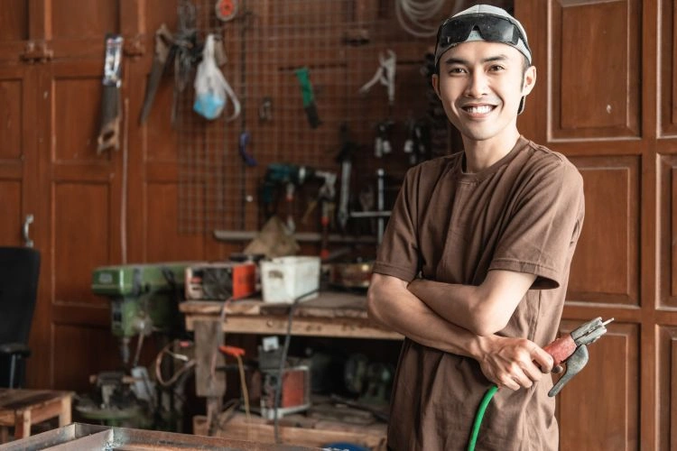 Homme debout dans son atelier de soudure