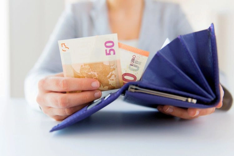 Femme tenant des billets en main pour représenter le récapitulatif des salaires par âge en France