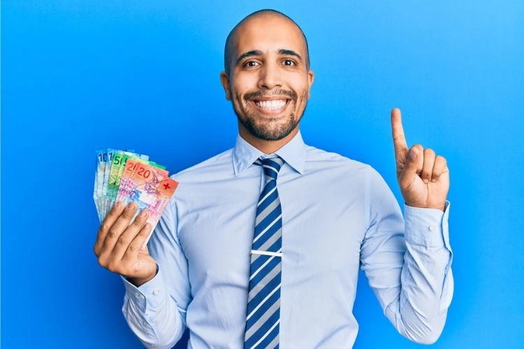 Homme entre 30 et 39 ans tenant des billets dans sa main