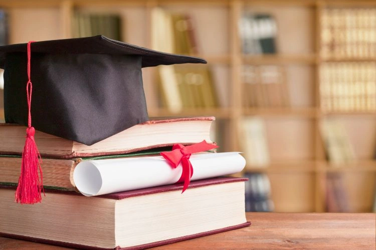 Chapeau de diplômé posé sur des livres