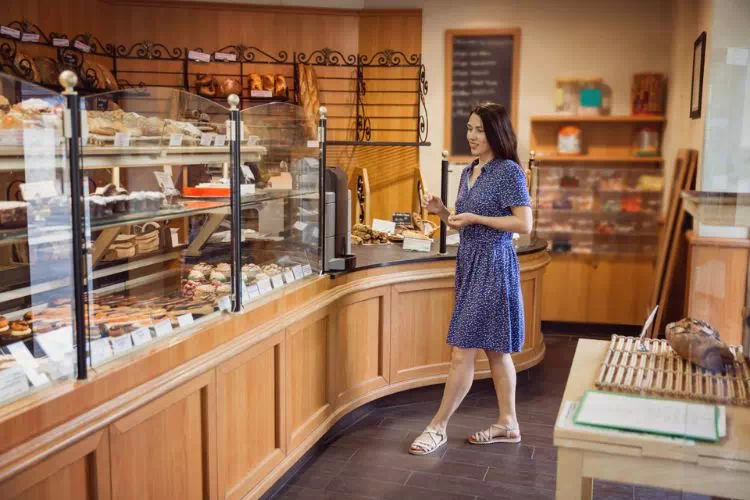 Jeune femme entrant dans une boulangerie