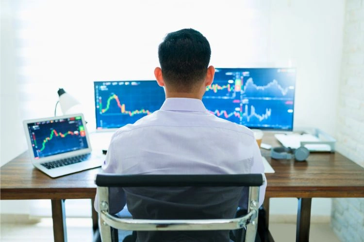 Homme devant des graphes de trading