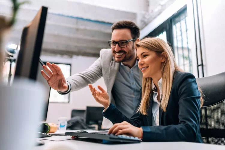 Deux collaborateurs d'un service marketing travaillant sur la campagne d'un client