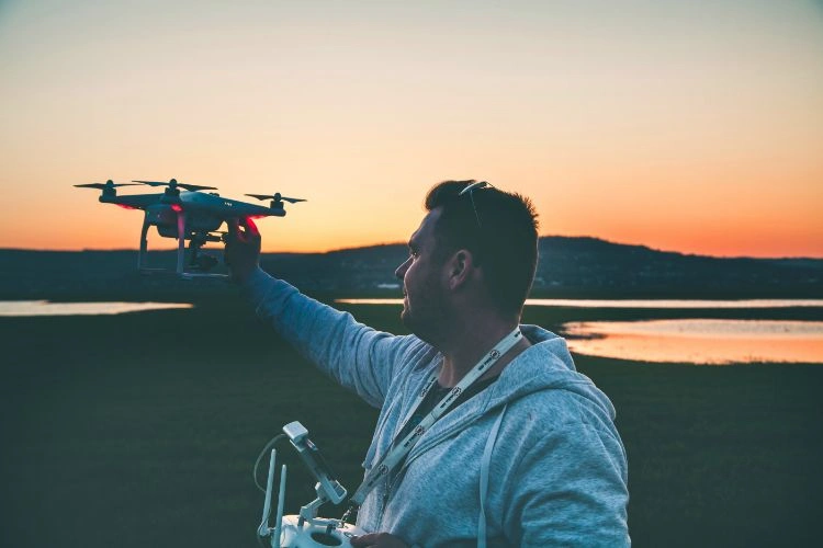 Homme guidant un drone