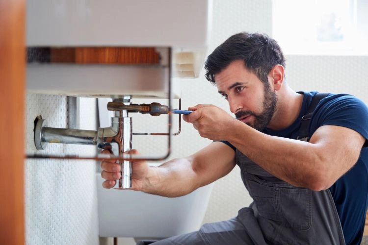 Homme travaillant sur un lavabo de douche