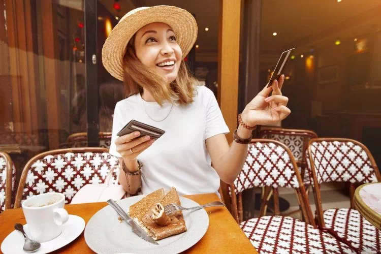 Femme utilisant un chèque-cadeau pour payer dans un restaurant