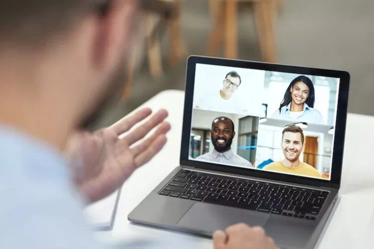 Homme devant son ordinateur et participant à un webinar