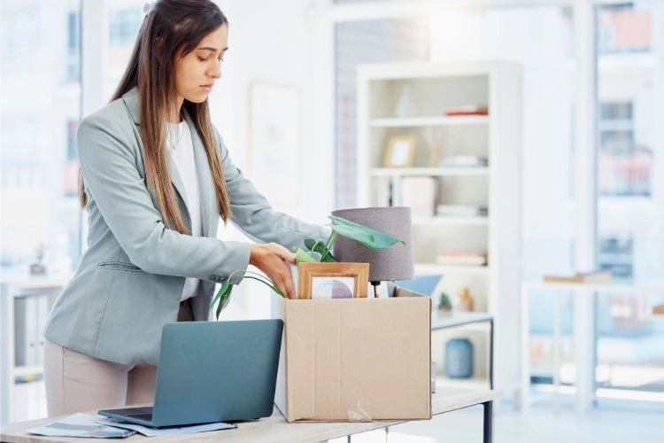 Femme ramassant ses affaires de bureau