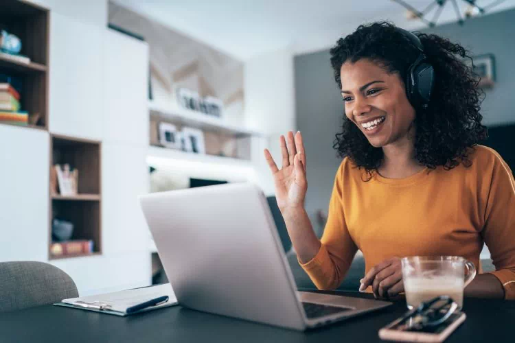 Freelance utilisant un logiciel de visioconférence pour échanger avec un client