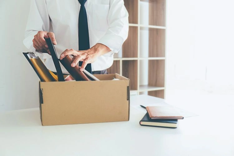 Personne licenciée rassemblant ses affaires de bureau