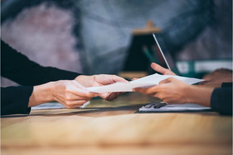 Patron remettant un document à son employé