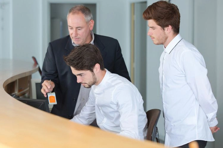 Deux jeunes hommes avec leur enseignant