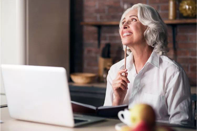 Femme réfléchissant devant la rédaction d'une lettre