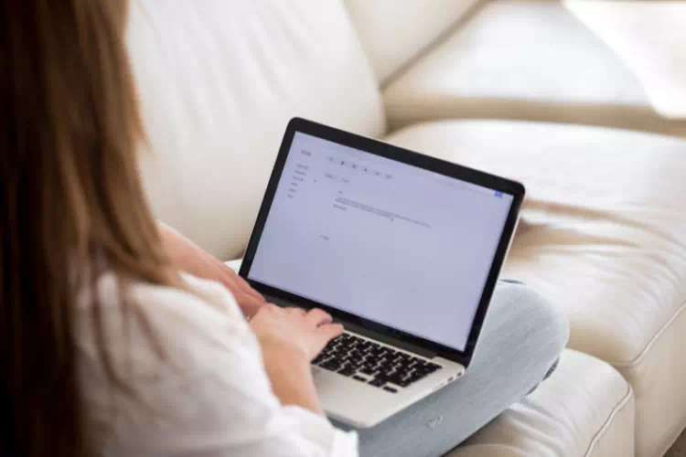 Personne rédigeant une lettre de motivation sur son PC
